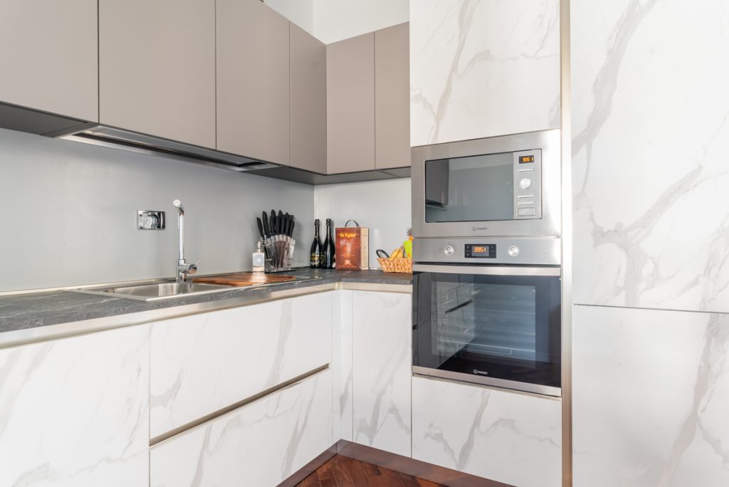 Cucina moderna con formo e microonde e mobili effetto marmo bianco