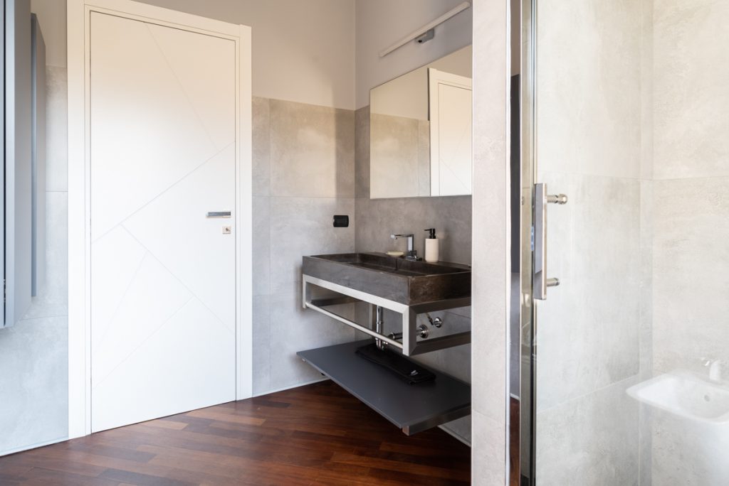 bagno con lavabo in marmo scuro e parquet