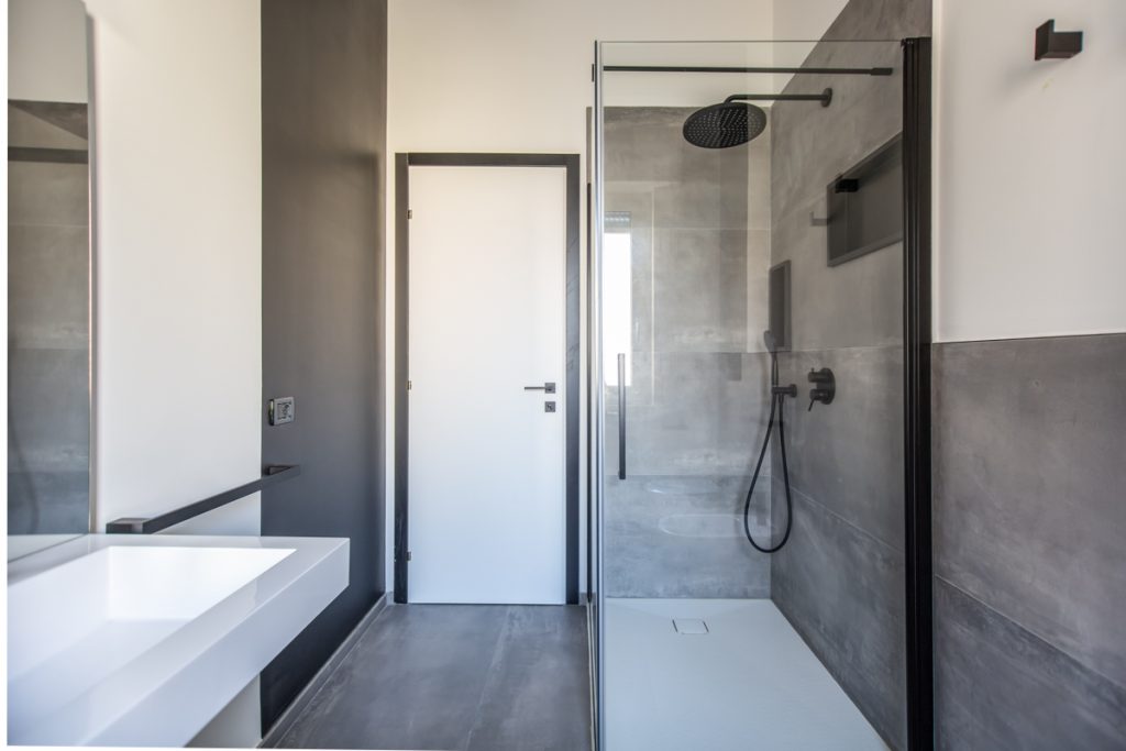 Bagno industrial con doccia vetrata