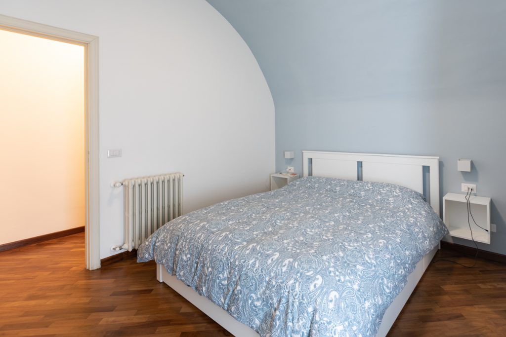 Camera da letto con parete azzurra a forma di arco.