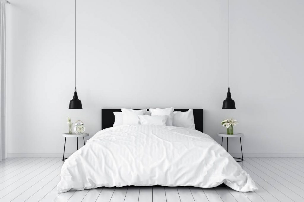 Camera da letto stile minimal con lampadario a sospensione nero.