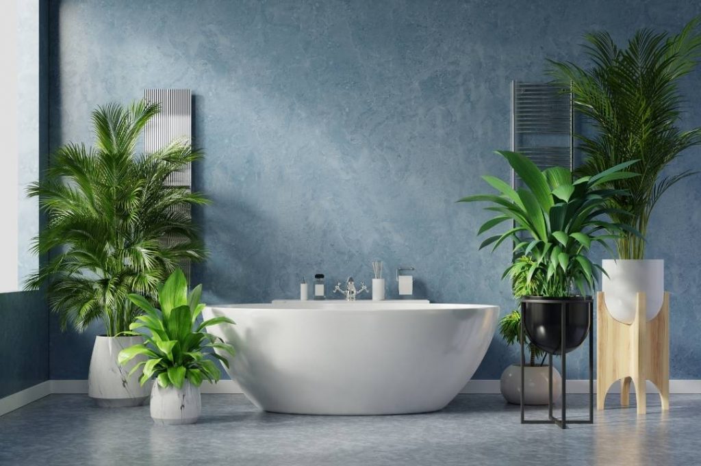 bagno moderno con resina. Vasca freestanding bianca e piante nel bagno.