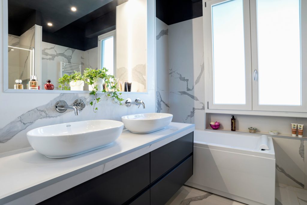 Bagno moderno con doppio lavabo d'appoggio di colore bianco.