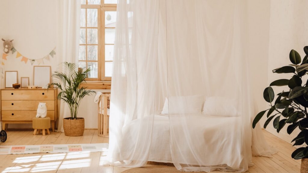 camera matrimoniale con letto a baldacchino bianco.