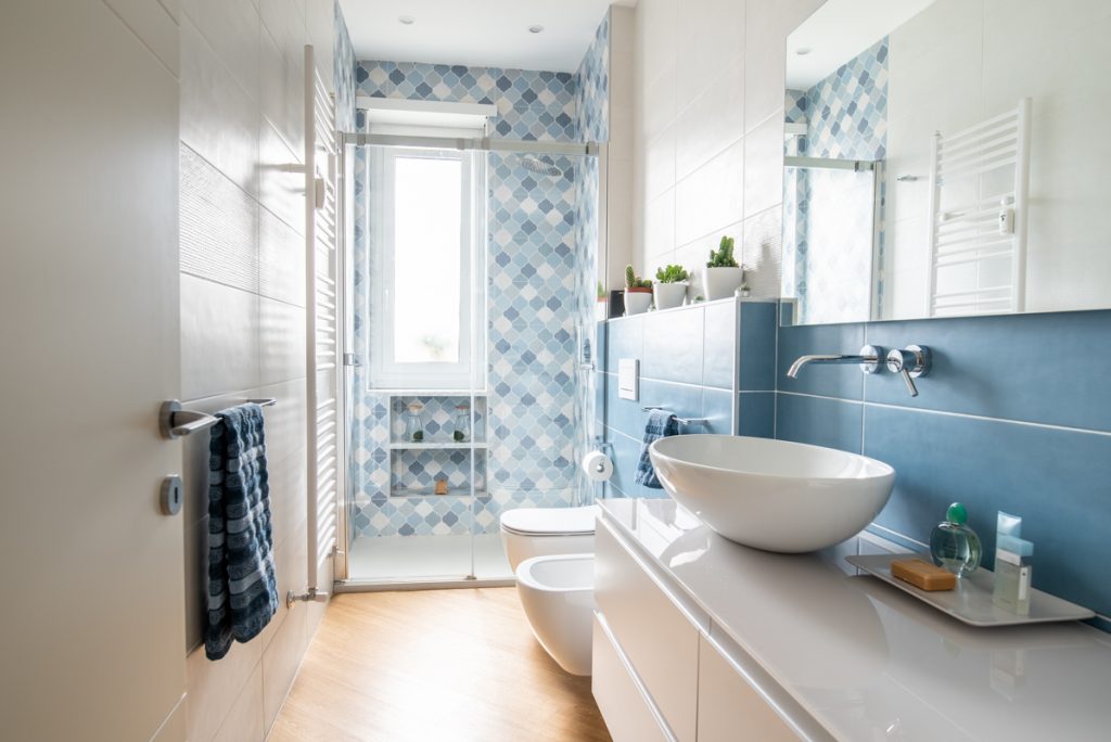 bagno moderno con lavabo d'appoggio e rivestimenti in ceramica blu.