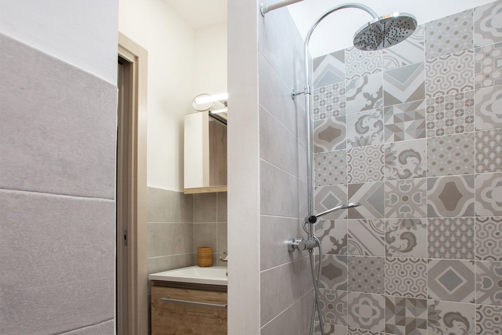 Ristrutturazione Lecce. Bagno rustico con doccia con piastrelle decorate.