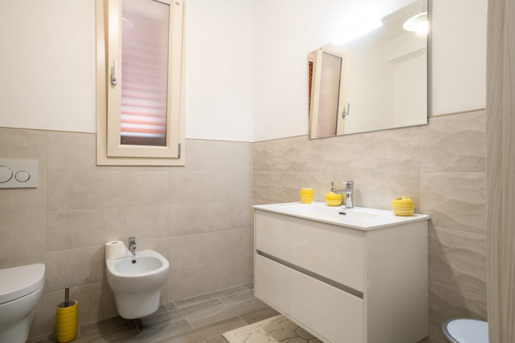 Bagno moderno con sanitari bianchi a sospensione.