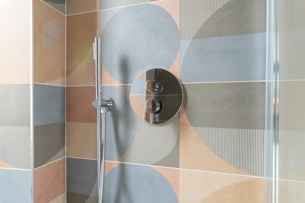 Piastrelle per bagno in gres porcellanato color pastello e forme geometriche.