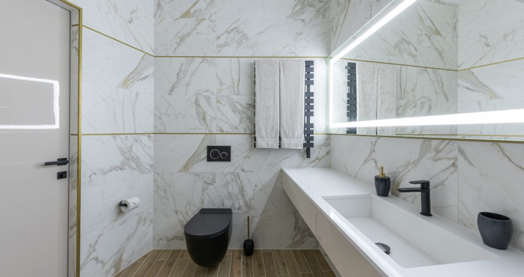 idee ristrutturazione bagno moderno con rivestimenti in marmo e sanitari bianchi e neri.