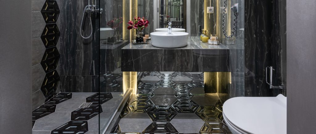 bagno con pavimento nero con forme geometriche.