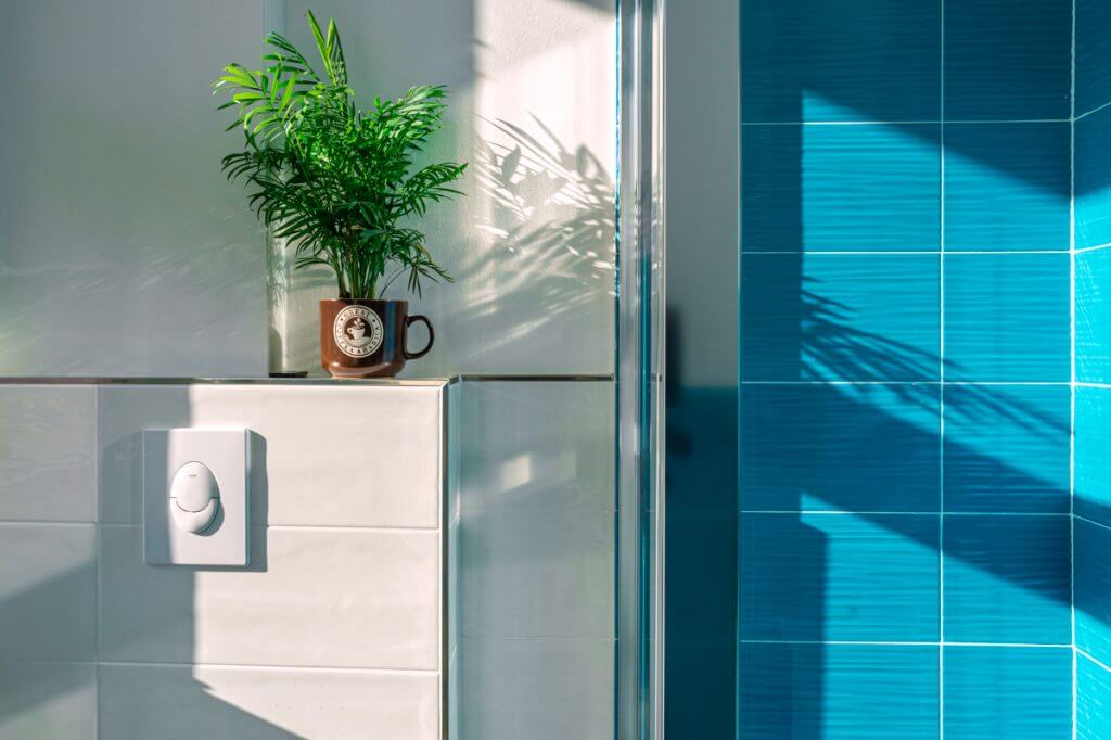 bagno con gres porcellanato blu e parete bianca