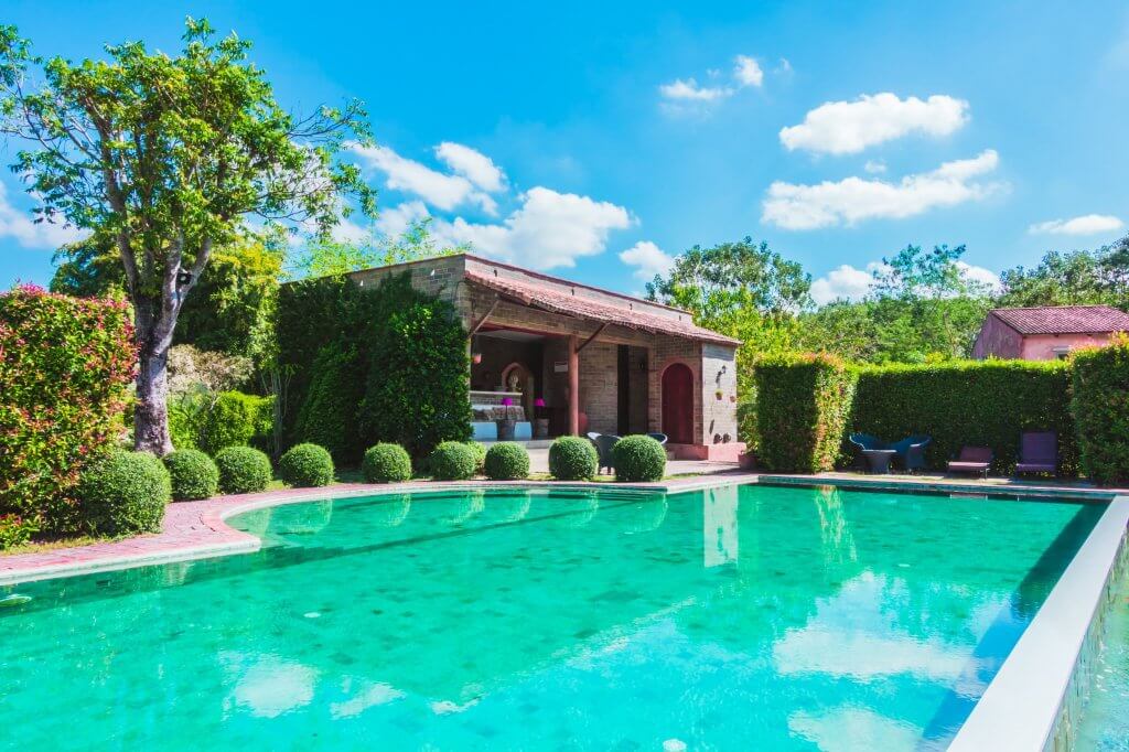 Casa con giardino e piscina, cespugli bordo piscina laterali