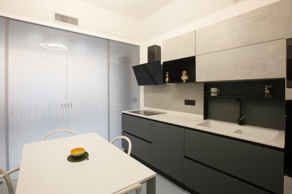 Progetto di ristrutturazione a Catania, cucina moderna scura con porta a vetri