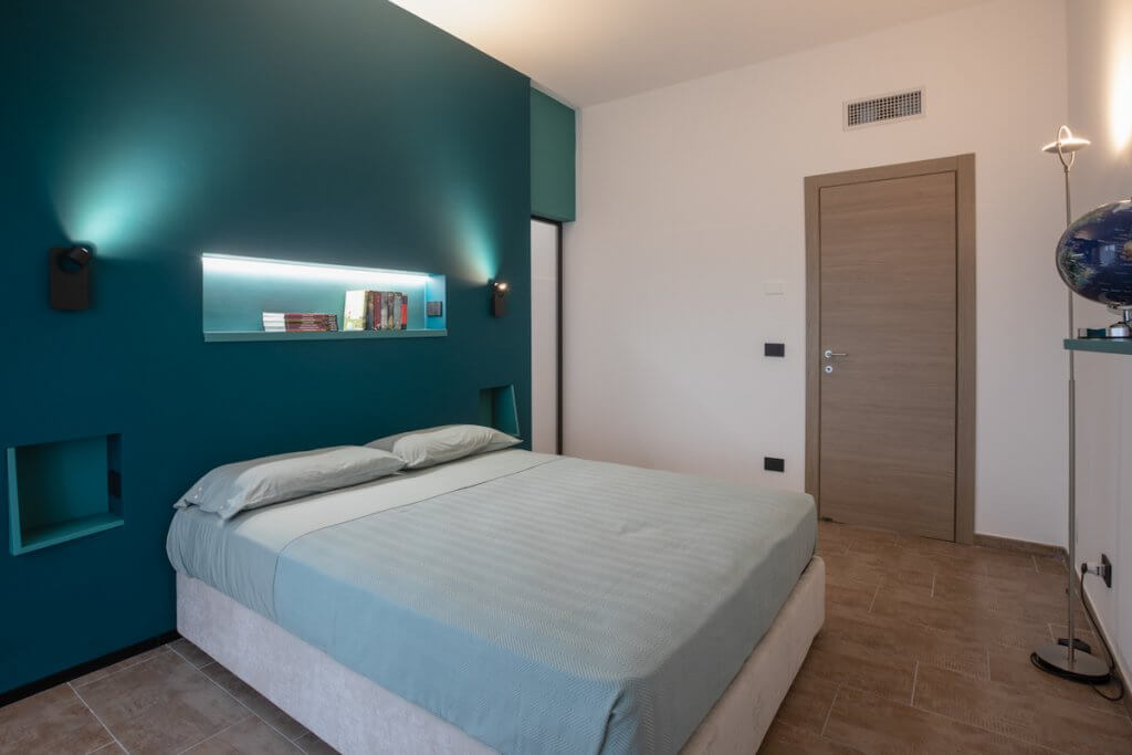 Progetto di ristrutturazione a Catania, camera da letto moderna parete verde petrolio