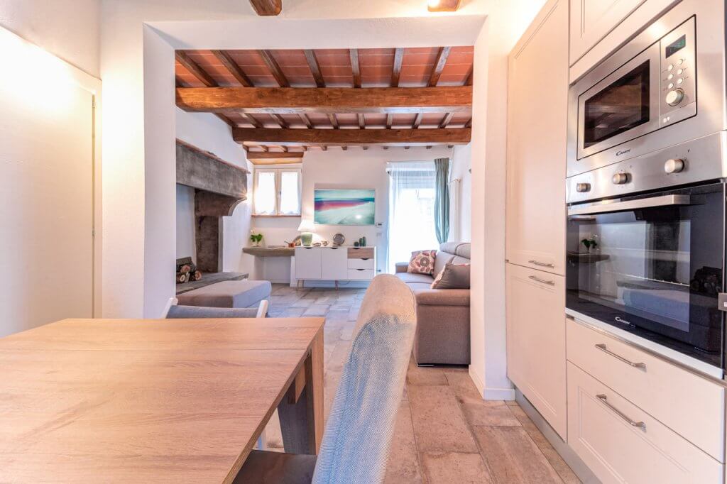 Soggiorno con cucina bianco, stile rustico, con rivestimento in legno bianco