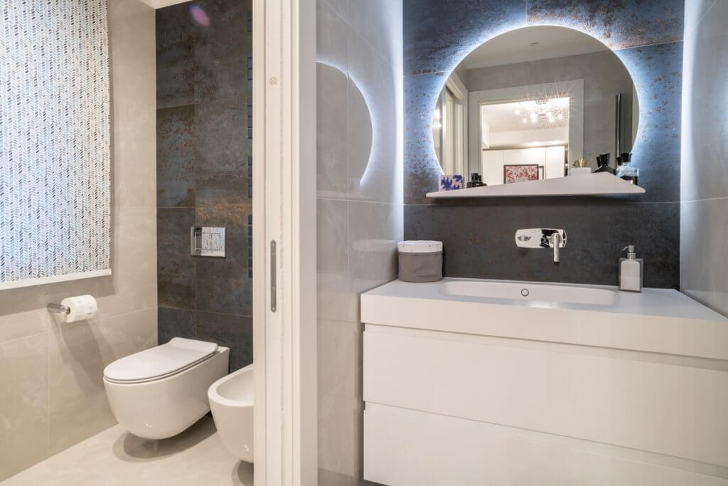 Ristrutturazione appartamento a Bisceglie, bagno moderno design specchio tondo sanitari