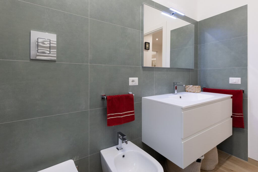 Ristrutturazione appartamento Palermo, bagno moderno rivestimento in gres porcellanato lavabo e bidet design