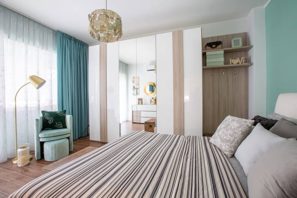 Ristrutturazione appartamento a Roma, camera da letto con gres effetto parquet, poltroncina pouf lampada