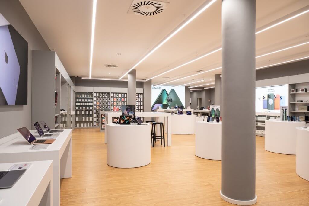 Store della Apple con pavimento in rivestimento in legno, cellulari di tanti colori e colonne di colore grigio