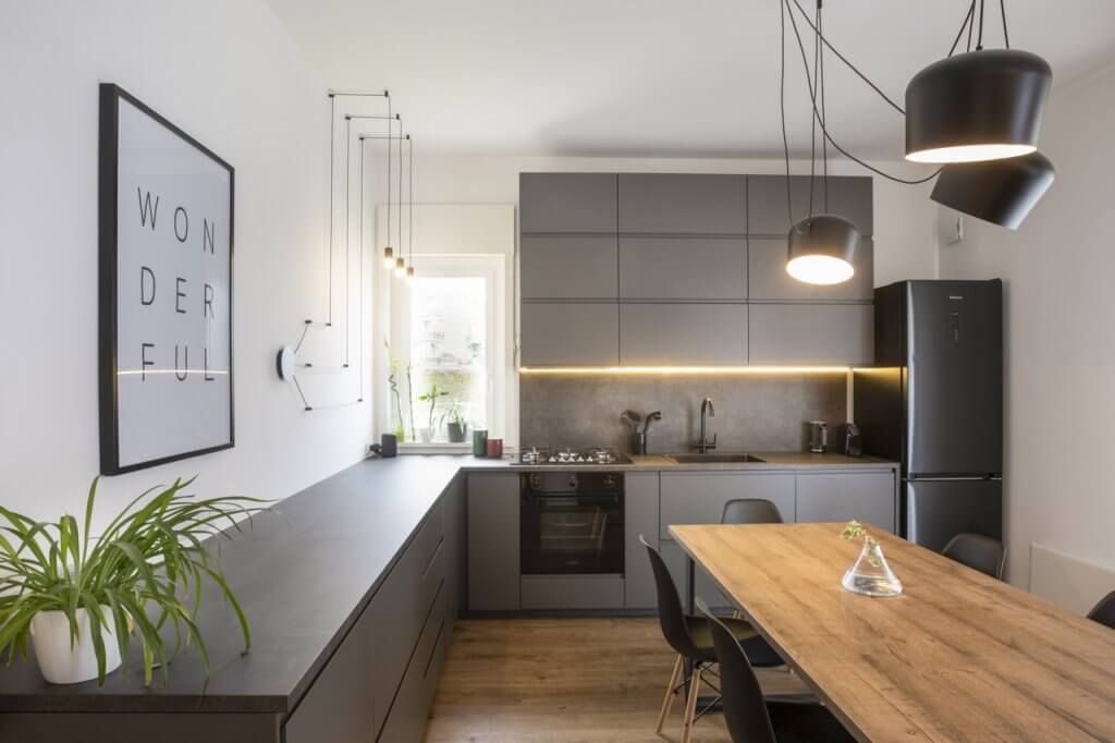 Cucina con design moderno di colore nero con rivestimenti in legno