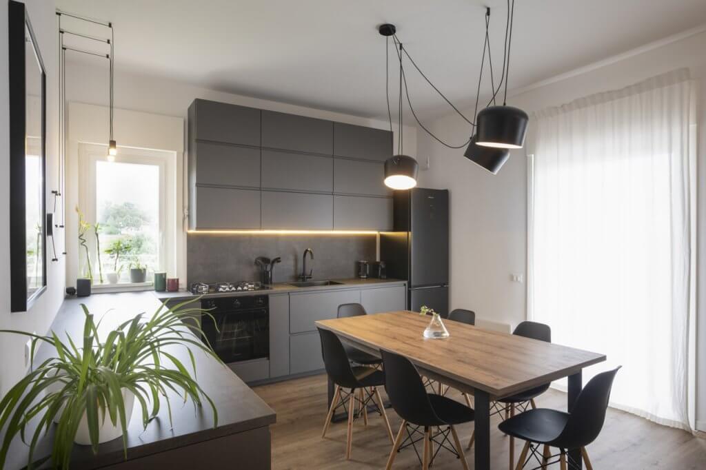 Cucina con rivestimenti in legno, illuminazione al led con lampade dal design moderno