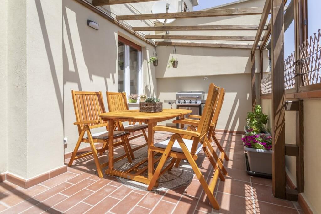 terrazzo di casa con tavolo e sedie in legno