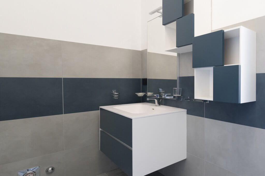 Lavandino del bagno con specchio, mobile dal design moderno e palette del blu e bianco