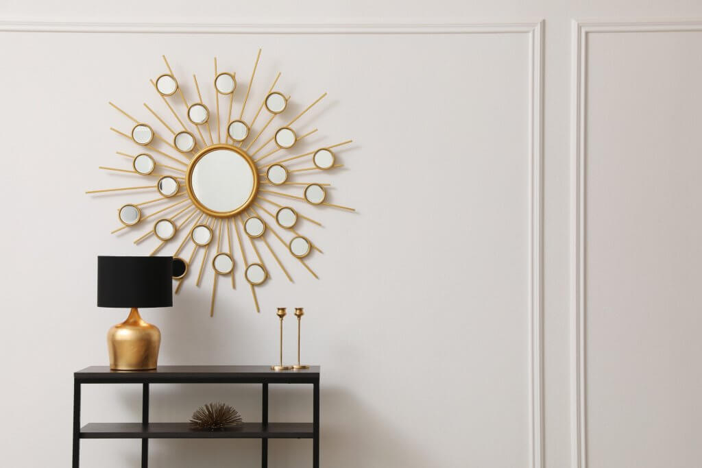 Specchi di design con rifiniture in oro con mobile nero e lampada