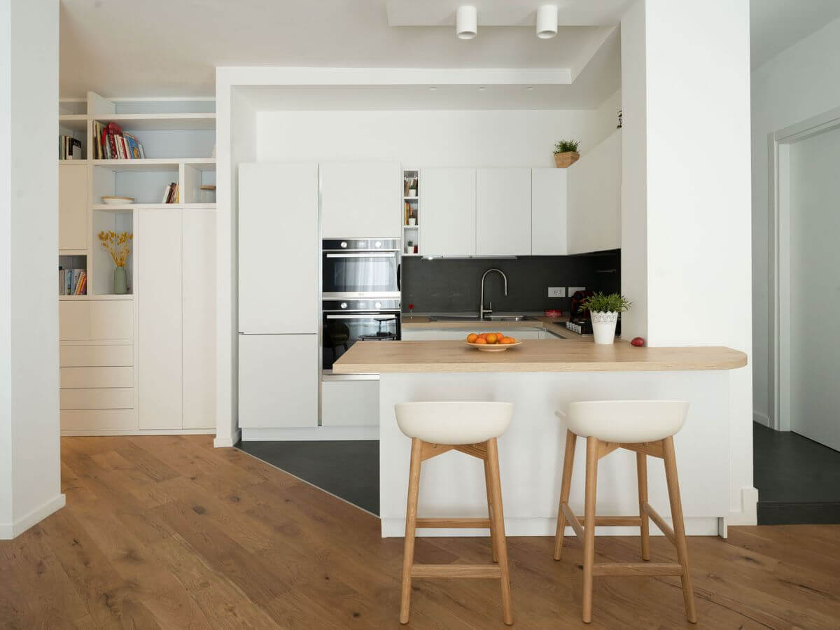 cucina moderna con open space e rivestimenti bianchi